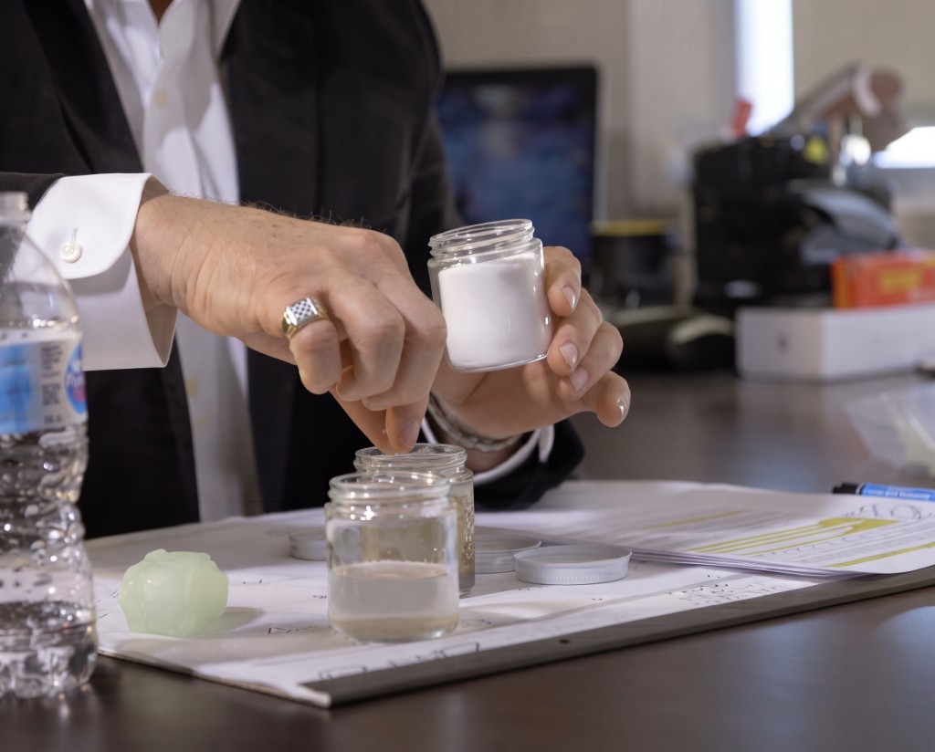 Jerry Hanna demonstrating Clearflow water treatment chemistry with lab jars